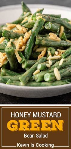 a white plate topped with green beans next to a brown and white sign that says honey mustard green bean