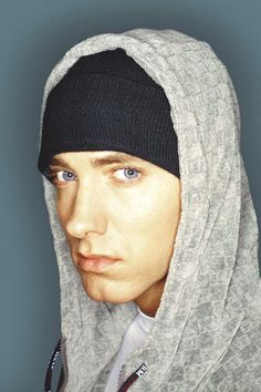 a young man wearing a hoodie and looking at the camera with an intense look on his face