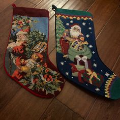 two christmas stockings sitting on top of a wooden floor next to each other with santa claus