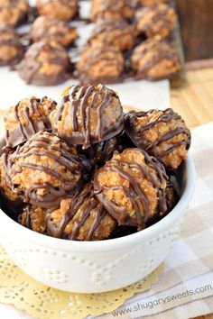 a white bowl filled with chocolate covered donuts