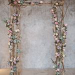 an old wooden frame decorated with flowers and branches for a wedding ceremony or special event