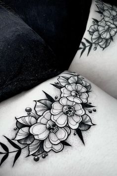 two women's thigh tattoos with flowers on them