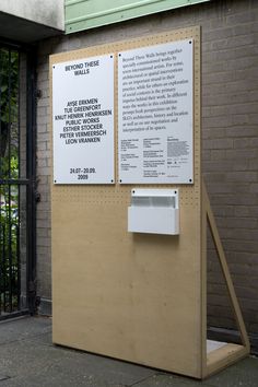 a sign on the side of a building that is next to a fence and gate