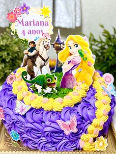 there is a birthday cake decorated with princess and frog figures on it's side