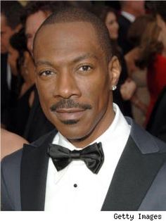 a man in a tuxedo and bow tie poses for the camera at an event