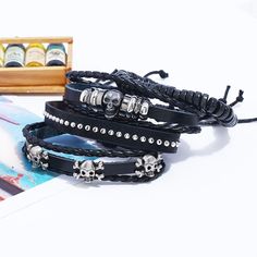 Whether you are into riding, playing your guitar or just hanging out and relaxing, this skull leather bracelet set will go well with any of your outfit. This black bracelet set comes with 4 separate bracelets. You can wear them as a set or individually to create a different look every time. The set consists of metal skulls, beads, leather and studs. Product Information Bracelet set comes with 4 separate bracelets Material: leather/PU leather Chain Type: rope chain Length: adjustable 7 - 8.5 inch Punk Style Adjustable Leather Bracelet, Black Skull Bracelets For Festival, Adjustable Black Leather Rocker Bracelet, Adjustable Punk Skull Jewelry, Adjustable Gothic Bracelets With Skull Print, Adjustable Punk Skull-shaped Jewelry, Adjustable Black Rock Bracelet, Trendy Black Braided Bracelets For Festival, Casual Black Leather Bracelet For Festivals