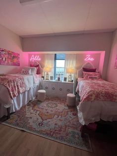 two beds in a room with pink lights on the walls and rugs around them