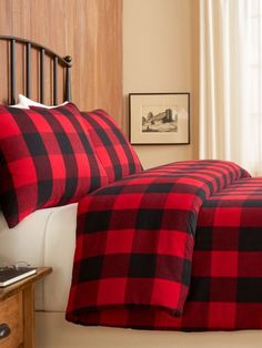 a red and black plaid comforter set on a bed