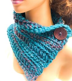 a close up of a mannequin wearing a blue and pink knitted cowl