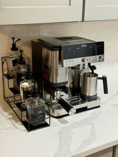 a coffee maker sitting on top of a counter next to some cups and saucers