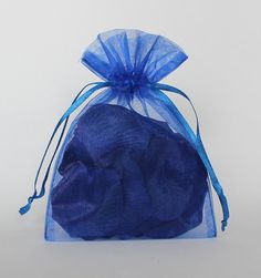 a blue organ bag filled with three balls of black fabric on top of a white surface