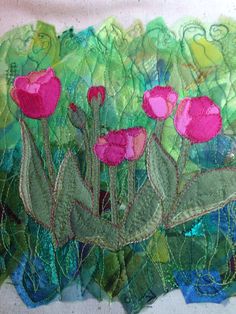 a close up of a piece of art with pink flowers on green and blue fabric