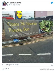 an advertisement is posted on the side of a road in front of a fenced off area