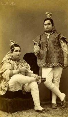 an old photo of two people dressed in costume