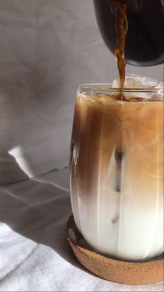 coffee being poured into a glass cup