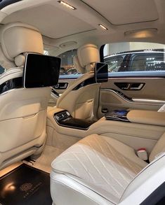 the interior of a luxury car with white leather seats