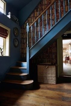 the stairs are made of wood and have bookshelves on them, along with wicker baskets