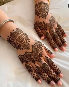 two hands with henna tattoos on them