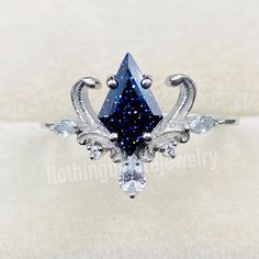 a fancy ring with blue and white stones on it's sides, set in silver