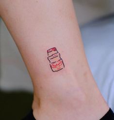 a small tattoo on the ankle of a woman with a jar of jam in it