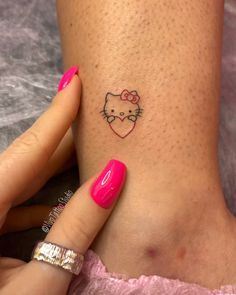 a woman's foot with a hello kitty tattoo on her left ankle and pink nail polish