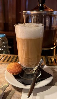 there is a cup of coffee and a cookie on the plate