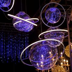 some blue lights hanging from the ceiling in front of a stage with chandeliers