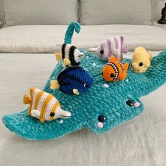 a crocheted fish pillow on top of a bed