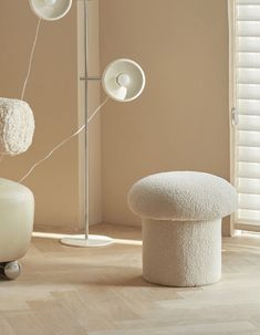 two white vases sitting next to each other on top of a hard wood floor