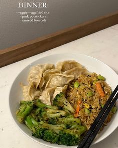 a white bowl filled with broccoli and rice next to chopsticks on a counter