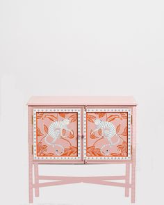 an orange and pink cabinet with two doors on each side, decorated with floral designs