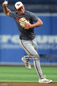 a baseball player pitching a ball on top of a field with his arm in the air