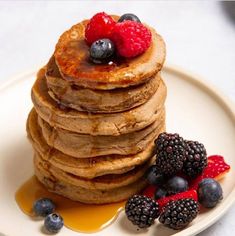 a stack of pancakes with berries and syrup