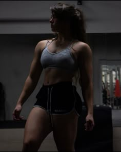 a woman in grey sports bra top and black shorts