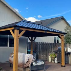 an outdoor covered patio with grills and furniture