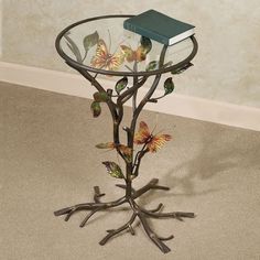 a glass table with butterflies on it and a book sitting on top of the base