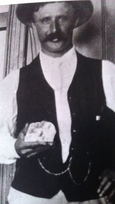 an old black and white photo of a man holding food