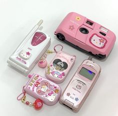 several different types of cell phones are arranged on a white surface with hello kitty accessories