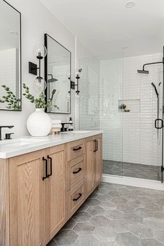 a bathroom with two sinks and mirrors on the wall