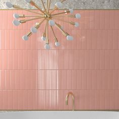 a bath tub sitting next to a pink tiled wall