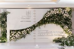 the wedding stage is decorated with white flowers and greenery