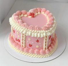 a pink heart shaped cake on a white plate