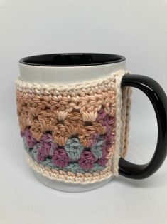 a crocheted coffee mug cozys up against a white background