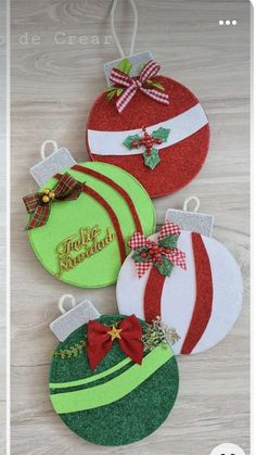 four christmas ornaments are hanging on a table