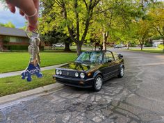 a car parked on the side of a road with a key in it's mouth