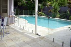 an empty swimming pool with glass fence around it