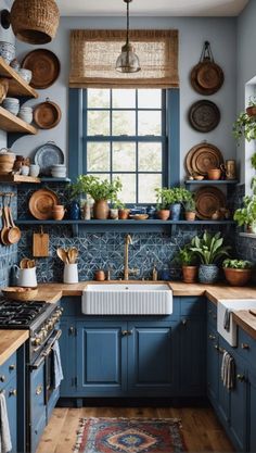 a kitchen with blue cabinets and lots of potted plants on the counter top,