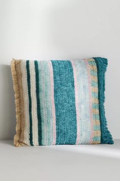 a striped pillow sitting on top of a white table