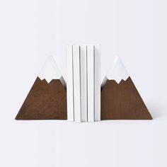 three books are stacked on top of each other in front of a white background with brown and white mountains