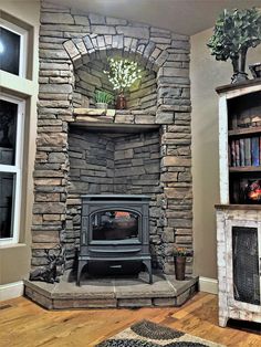 a living room with a stone fireplace and bookshelves on the wall next to it